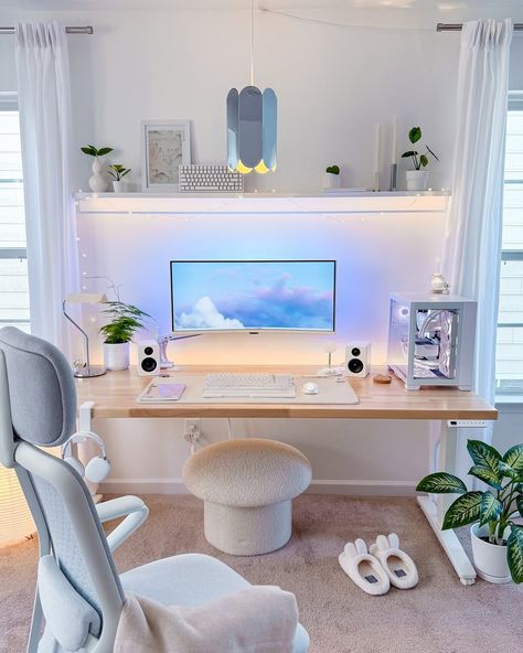A cozy desk setup with computer screen, keyboard and study light
